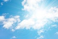 Bright sun on a blue sky with white clouds. Sunny sky as a background. Peaceful sky Royalty Free Stock Photo