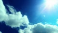 A bright sun in a blue sky among white fluffy clouds. The sun\'s rays in the blue sky. Generated by AI. Royalty Free Stock Photo