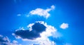 The bright sun breaks through the white cloud, the rays of the sun break through. Blue bright clear sky. Royalty Free Stock Photo