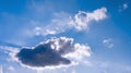 The bright sun breaks through the white cloud, the rays of the sun break through. Blue bright clear sky. Royalty Free Stock Photo