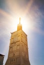 The bright sun disappeared against the old lighthouse. Royalty Free Stock Photo