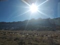 Bright sun hanging over the distant ridge in Utah