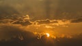 Bright sun in an orange sky with dark clouds at sunset Royalty Free Stock Photo