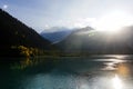 Bright sun rays over mountain lake