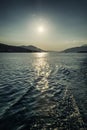 Bright sun on the sea against the backdrop of the mountains. Beautiful calm landscape. Vertical Royalty Free Stock Photo