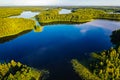 Bright sun shines above blue lakes and green forest, aerial landscape