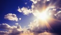 The bright sun shines from behind the clouds in the blue sky. The sun\'s rays shine on the clouds. International Sun Day Royalty Free Stock Photo