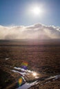 Bright sun shines over low clouds above vast and empty land along Volcanic Loop Hwy and Desert Road. Central Plateau