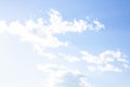 The bright sun shines on white, fluffy clouds in a blue sky. Heavenly background Royalty Free Stock Photo