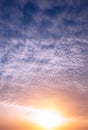 Bright sun at sunset on the background of clouds and blue sky Royalty Free Stock Photo