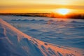 Bright sun at sunset in winter with large snow drifts. Royalty Free Stock Photo