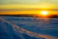 Bright sun at sunset in winter with large snow drifts. Royalty Free Stock Photo