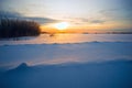 Bright sun at sunset in winter with large snow drifts. Royalty Free Stock Photo