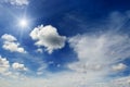 Bright sun and white clouds on the background of an blue sky. Royalty Free Stock Photo