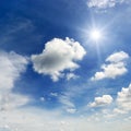 Bright sun and white clouds on the background of an blue sky. Royalty Free Stock Photo