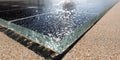 Close-up view of a solar panel edge reflecting sunlight with a textured surface on a sandy background during the Royalty Free Stock Photo