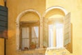 Bright sunlight reflected in windows with open shutters in old house Royalty Free Stock Photo