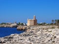 Bright sunlit view of the cliffs and coast in ciutadella menorca with deep blue sea and rocky cliffs with the historic castle an