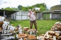 On a sunny summer day, a man is chopping firewood in the yard