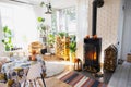 Bright sunny interior of the house with Black Metal Steel fireplace stove with fire and firewood with halloween decor and autumn