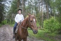 On a sunny summer day in the forest  a boy riding a horse Royalty Free Stock Photo