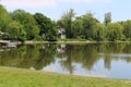 Bright sunny tree lined lake reflection blue sky Royalty Free Stock Photo