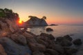 Bright sunrise in Lloret de Mar. Spain nature landscape in the morning. Sun shines through cliff on sea beach in Costa Brava Royalty Free Stock Photo