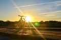 Bright sunrise on the road near the river on the background of a bicycle. Mountain bike in forest with sun rays. Royalty Free Stock Photo