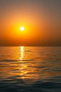 Bright sunset with large yellow sun under the sea surface. Beautiful sunset over the sea. Royalty Free Stock Photo