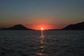 Bright sunset with large yellow sun under the sea surface. Beautiful Sunset in tropical Komodo island, Labuan Bajo, Fores,