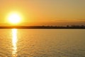 Bright sunset over the lake. Ripples on the water. The sky is orange Royalty Free Stock Photo