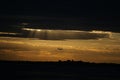 Bright sunset over a rural field with a silhouette of a landing plane Royalty Free Stock Photo