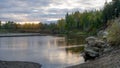 Bright sunset with reflection in the water of a small river Kempendyay in Yakutia between the cliffs and spruce forests Royalty Free Stock Photo