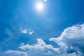 Bright sunshine with sun flares and clouds on clear blue sky background, hot summer concept Royalty Free Stock Photo