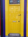 Bright sunshine yellow door with navy blue painted walls