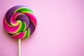 Bright swirl lollipop on pink background with copy space Royalty Free Stock Photo