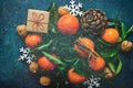 Bright Tangerines Green Leaves Pine Cones Gift Box Snow Flakes on Dark Blue Background.Sparkling Glitter Lights Christmas New Year