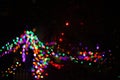 Bright threads of multi-colored garlands in the blur on the branches of the Christmas tree Royalty Free Stock Photo