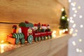 Bright toy train and Christmas lights on wooden shelf, closeup. Space for text Royalty Free Stock Photo
