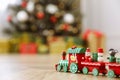 Bright toy train on floor in room with Christmas tree Royalty Free Stock Photo