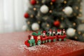 Bright toy train on table in room with Christmas tree Royalty Free Stock Photo