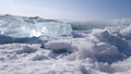 Bright transparent blue ice floe lies on the snow on the surface of lake Baikal. Winter in Siberia, Russia Royalty Free Stock Photo