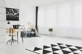 Trendy bedroom interior with copy space and black and white patterned rug on the floor