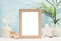 Bright tropical mock up with beige photo frame, palm leaves in vase and home decor on blue background