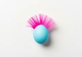 Turquoise easter egg with pink feather mohawk on white background Royalty Free Stock Photo