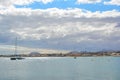 Bright turquoise ocean with two sail boats, in the background the town of Corralejo. Fuerteventura, Spain.