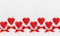 Bright valentine`s day background - sweet red lollipops hearts on white wood board as seamless border, layout for banner, header.