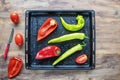 Bright vegetables on black baking sheet. Green and red peppers, tomatoes. Rustic table. Copy space Royalty Free Stock Photo