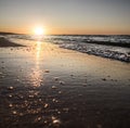 The bright warm setting sun is reflected in the mirror surface of the breaking wave of the Black Sea Royalty Free Stock Photo