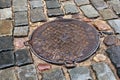 Bright wet stones of the sidewalk after the rain with a sewer hatch Royalty Free Stock Photo